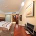 Hubin Bubugao Hotel in Qingyuan guest room with a bed, desk, TV, and wood floor