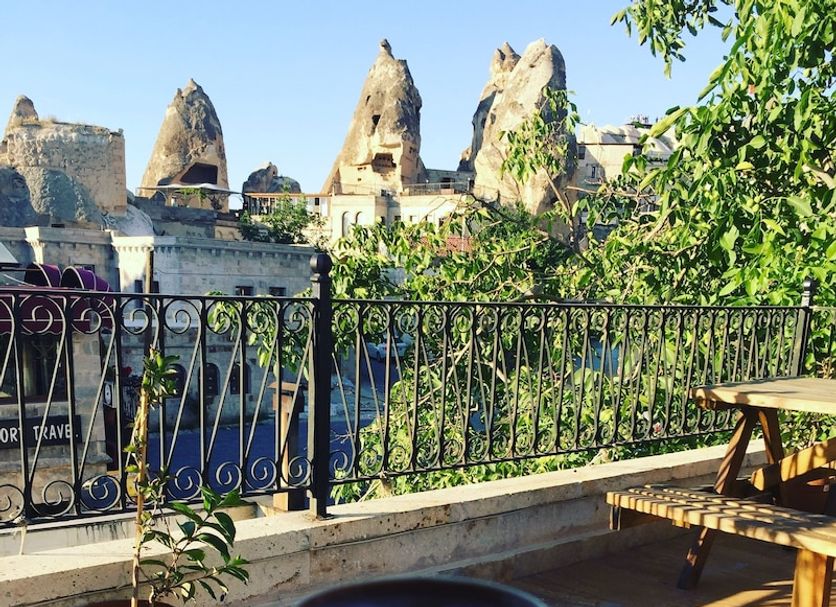 Cappadocia Ozbek Stone House in Göreme terrace with coffee cup and Cappadocia rock views