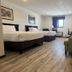 Home Suites Thief River Falls guest room with two beds, armchair, and window view