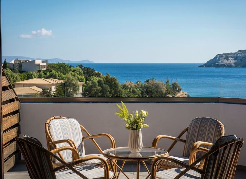 Alexander House Hotel in Agia Pelagia balcony with table, chairs, and sea view