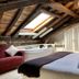 Palacio Torre de Ruesga in Valle: attic suite with skylight, exposed beams, sofa, and sofa-shaped bath tub