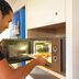 Hotelf1 Narbonne Sud in Narbonne: guest using a microwave in a hotel kitchenette