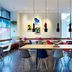 citizenM Austin Downtown lobby with long communal tables, colorful seating, floor-to-ceiling windows and wall art