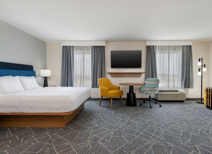 Hampton Inn Detroit/Southgate guest room with king bed, desk, TV, and seating area in Southgate