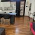 Flamingo B&B in Pompei kitchen and dining area with island, black chairs, and wood flooring