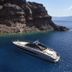 Villaki Oia in Oia with a luxury yacht on deep blue water beside rocky seaside cliffs