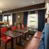 Hampton Inn Battle Creek breakfast area with tables, bar seating, and large windows