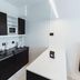 Cyan Recoleta Hotel in Buenos Aires kitchen area with black cabinets, sink, microwave and coffee maker