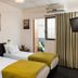 Sun City Hotel in Tel Aviv guest room with two single beds, wall art, air conditioner and curtains