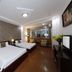 Vilion Central Hotel in Ho Chi Minh City guest room with two beds, desk, TV and wood flooring