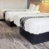 Americas Best Value Inn & Suites Senatobia guest room with two beds and wood headboard