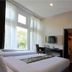 Vio Hotel Cimanuk Bandung guest room with twin beds, wall-mounted TV and large window in Bandung