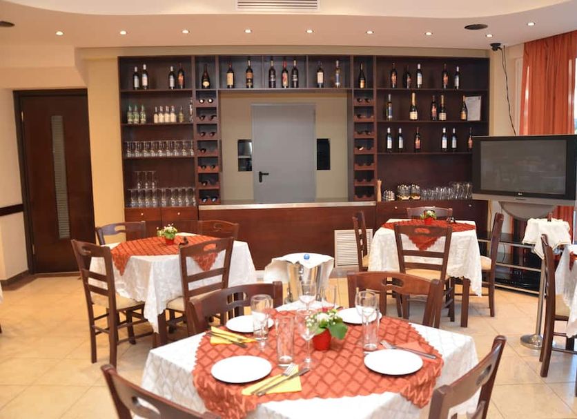 Marine Congo Hotel Rhodes dining room with set tables, chairs, bar shelves, and TV