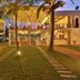 Arugambay Roccos in Arugam, illuminated beachfront hotel exterior with palm trees and glass facade
