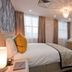 W12 Rooms London hotel room with bed, desk, TV, and chandelier lighting