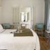 La Palmeraie in La Baule-Escoublac room with king bed, chairs, vanity and curtain-draped window