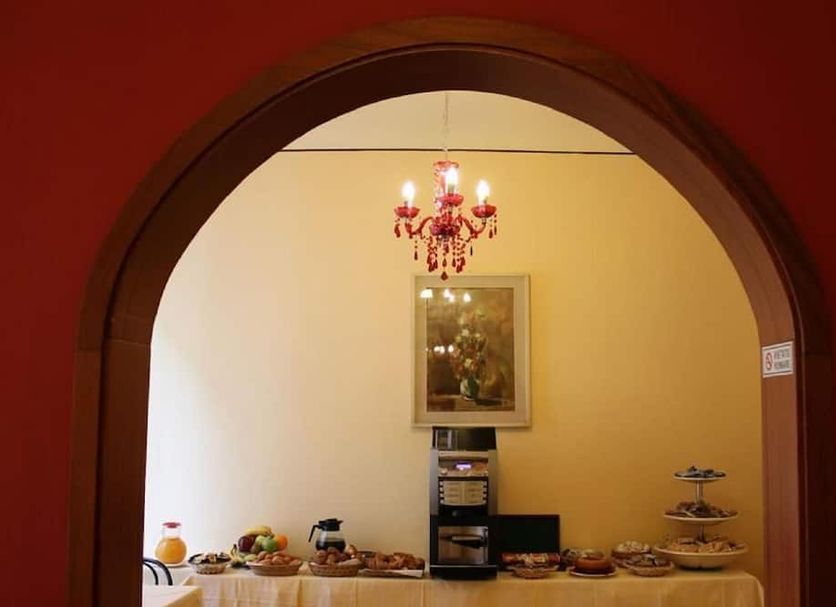 Hotel Romagna Florence archway view of breakfast buffet and chandelier in dining area