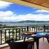 Gentl Grown Sanya Seashore balcony with table, chairs, and sweeping sea and mountain views in Sanya