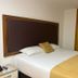 Hotel Dorado Ferial Bogotá guest room with king bed and gold accents