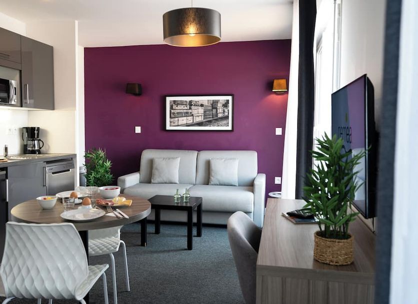 Nemea Appart Hotel Quai Victor Tours Centre apartment with kitchenette, sofa and purple accent wall in Tours