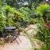Lands in Love Hotel and Resort in San Lorenzo tropical garden patio with outdoor tables and chairs