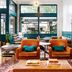 Arrive Memphis lobby with orange armchairs, teal walls, and large front windows in Memphis