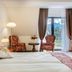 Hotel Paryski Art & Business in Zakopane guest room with twin beds, balcony view, and floral armchairs