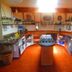 Sans Souci Inn in Pohara kitchen with central island, tile floor, shelves, sink and oven
