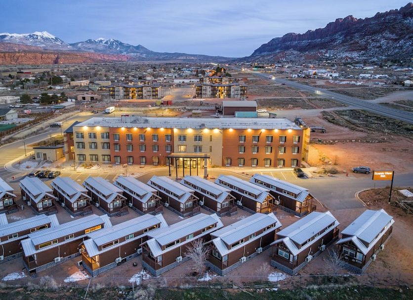 Scenic View Inn & Suites Moab in Moab with mountain views and parked shuttle buses at dusk