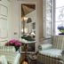 La Dimora Dei Monaci in Siena: striped armchairs, mirror, side table, and window in a bright lounge