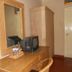 Bali Lovina Beach Cottages in Buleleng with wood dresser, mirror, TV and wardrobe in a guest room