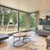 Center Parcs De Vossemeren in Lommel, living room with sofa and forest-view patio doors