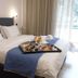 Anastazia Luxury Suites & Spa in Diónysos guest room with neatly made bed and breakfast tray by window