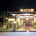 Mirah Hotel & Resort Banyuwangi entrance at night with illuminated reception and tropical landscaping
