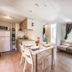 hu I Pini village in Fiano Romano: bright open-plan suite with kitchen, dining table, sofa and window seat