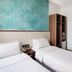 The Quay Hotel West Coast, Singapore twin room with two single beds, side table, and wardrobe