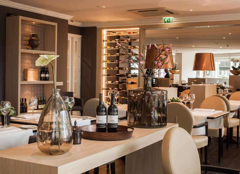 Golden Tulip Leiden Centre restaurant with set tables, wine display and warm modern dining room