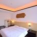 Oriental Hotel Dongguan guest room with king bed, warm ceiling lighting, and hallway view