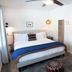 Sierra Blue Hotel & Swim Club room in Big Bear Lake with king bed, blue throw, and bathroom doorway