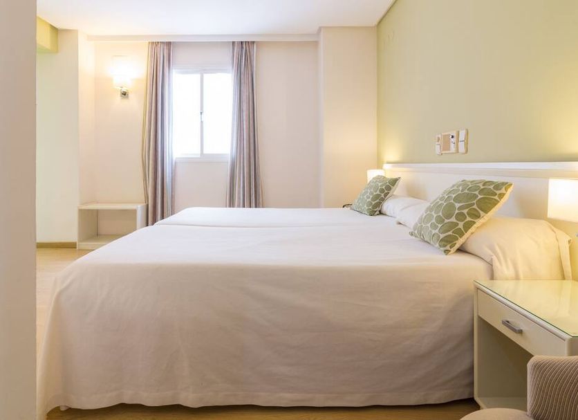 Platería in Écija bedroom with two beds, window and bedside lamps in a bright room