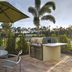 TownePlace Suites by Marriott Naples patio with grill, table, umbrella, and palm-lined view