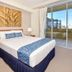Pumicestone Blue in Caloundra bedroom with king bed and balcony view through sliding glass doors