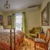 Auberge Marquis de Montcalm room in Sherbrooke with wrought-iron bed, green curtains and wood floors