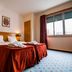 Residencial Lar do Areeiro in Lisbon guest room with twin beds, bedside lamps and window curtains