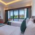 Sterling Karwar in Karwar guest room with two beds, TV, and window views of greenery and buildings