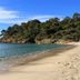Hotel La Voile in Bormes-les-Mimosas with a sandy beach and clear blue sea beside a wooded headland