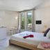 Vacancéole - Le Domaine De Chames room with bed, TV, table, and balcony doors in Vallon-Pont-d'Arc