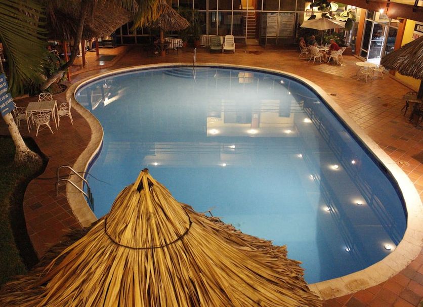 Gran Hotel Paris in La Ceiba with an outdoor pool and thatched palapa seating area