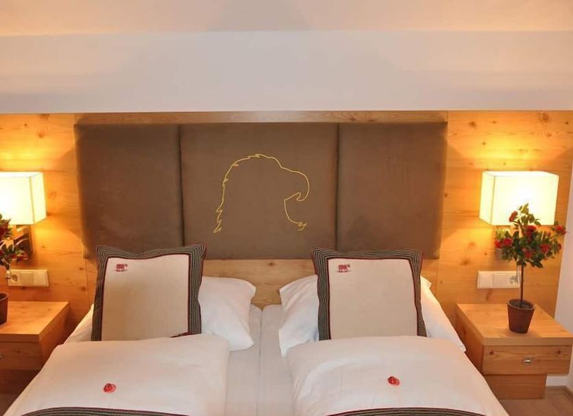 Hotel Goldener Adler Wattens guest room with twin beds, bedside lamps, and padded headboard