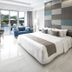 R Hotel Rancamaya Bogor guest room with king bed, sofa, balcony doors and pool view